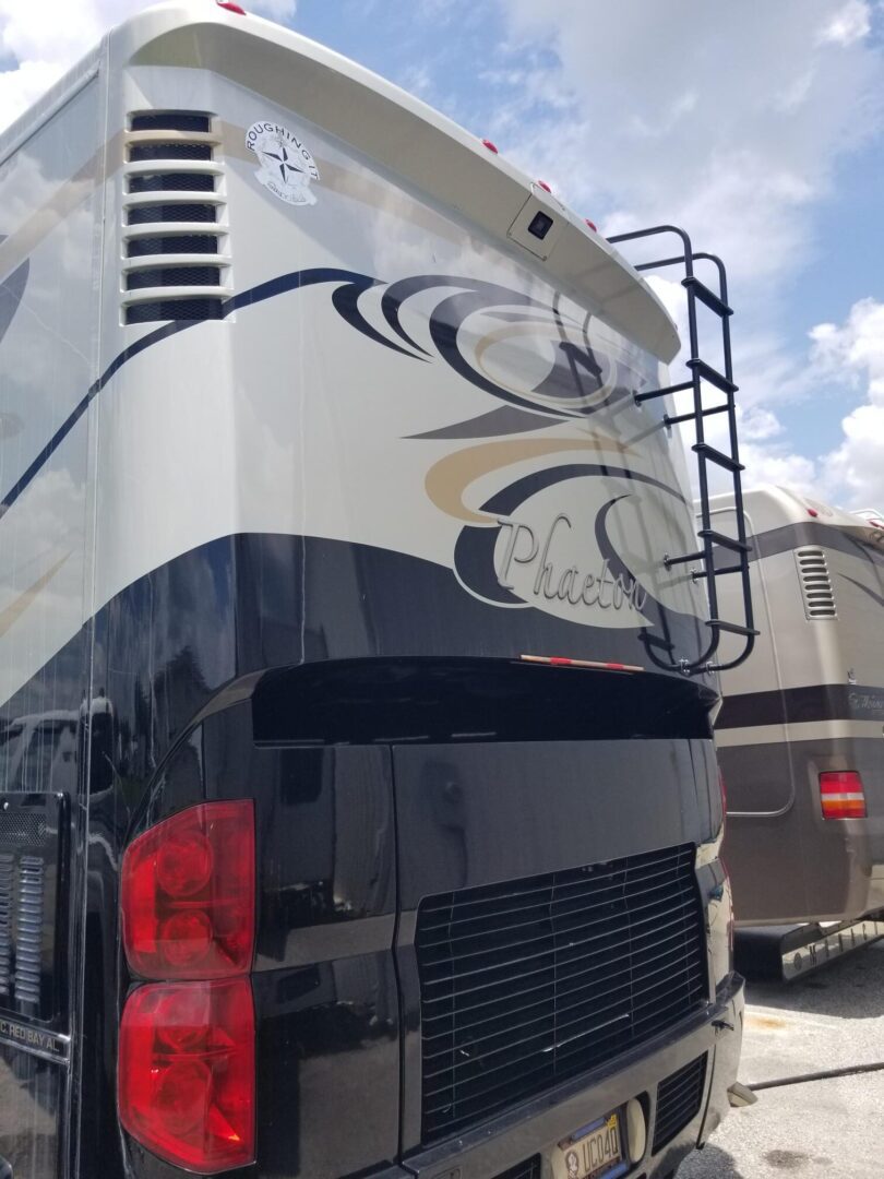 A black and white rv parked in a lot.
