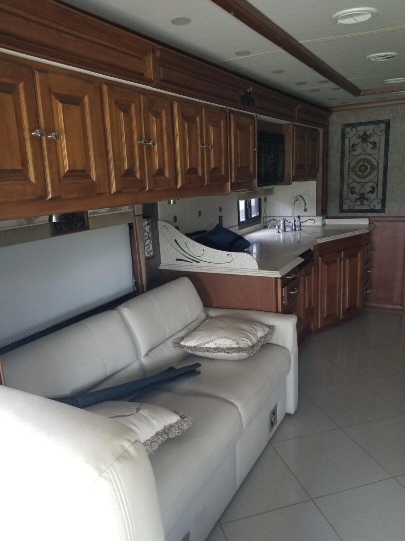 An rv with a couch and a kitchen in it.