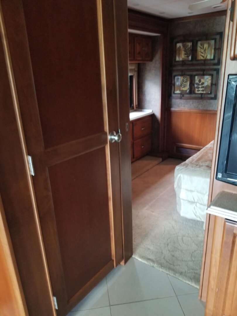 A room in an rv with a tv and a door.