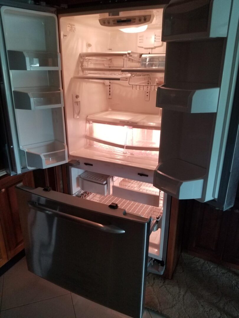 A refrigerator with the door open in a kitchen.