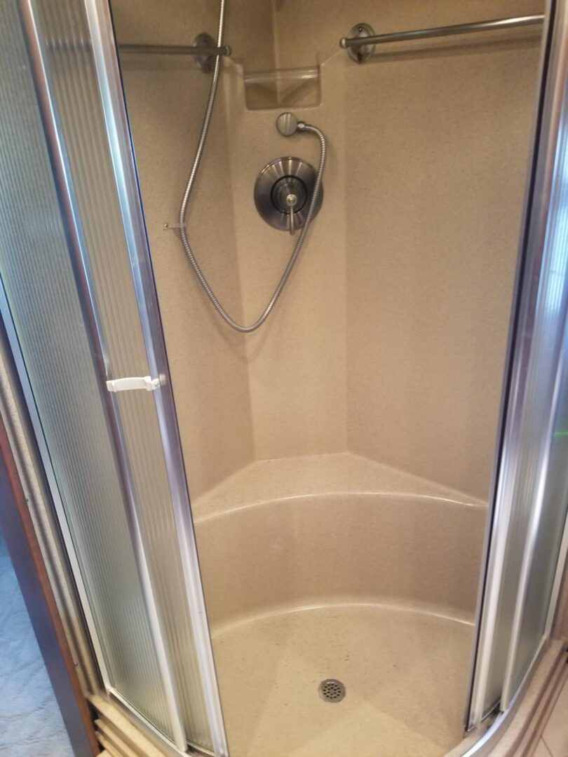 A shower in a bathroom with a glass door.