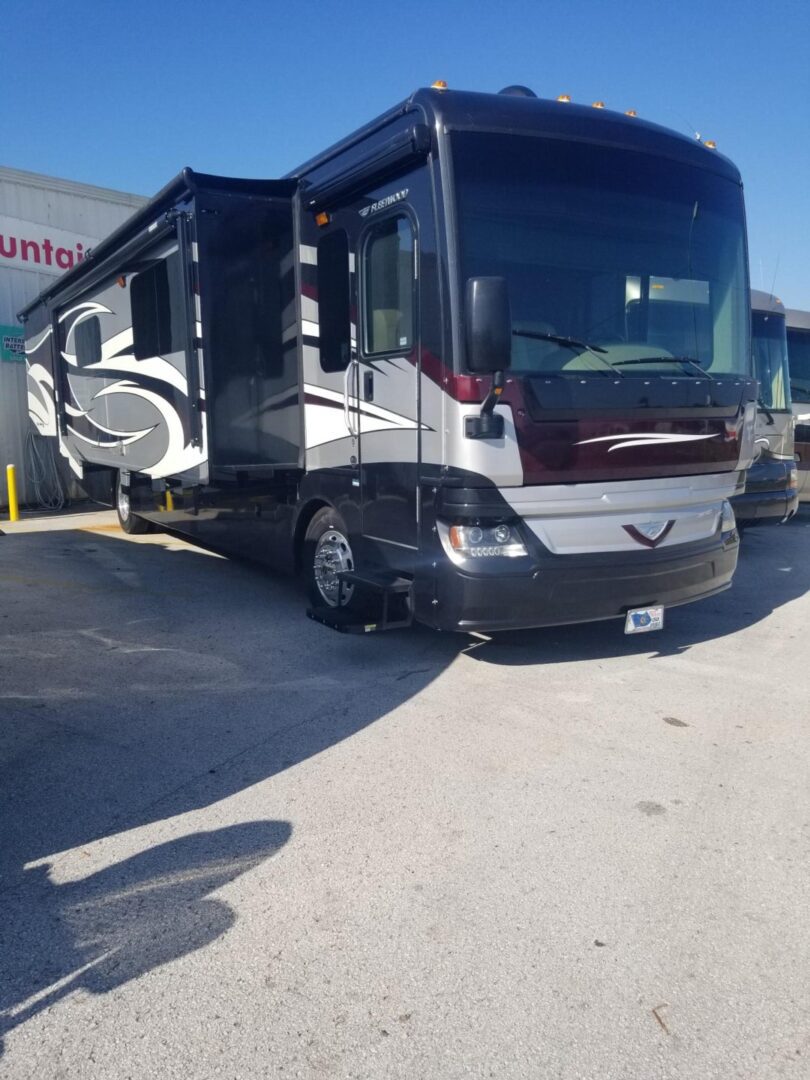 A black and white rv parked in a parking lot.