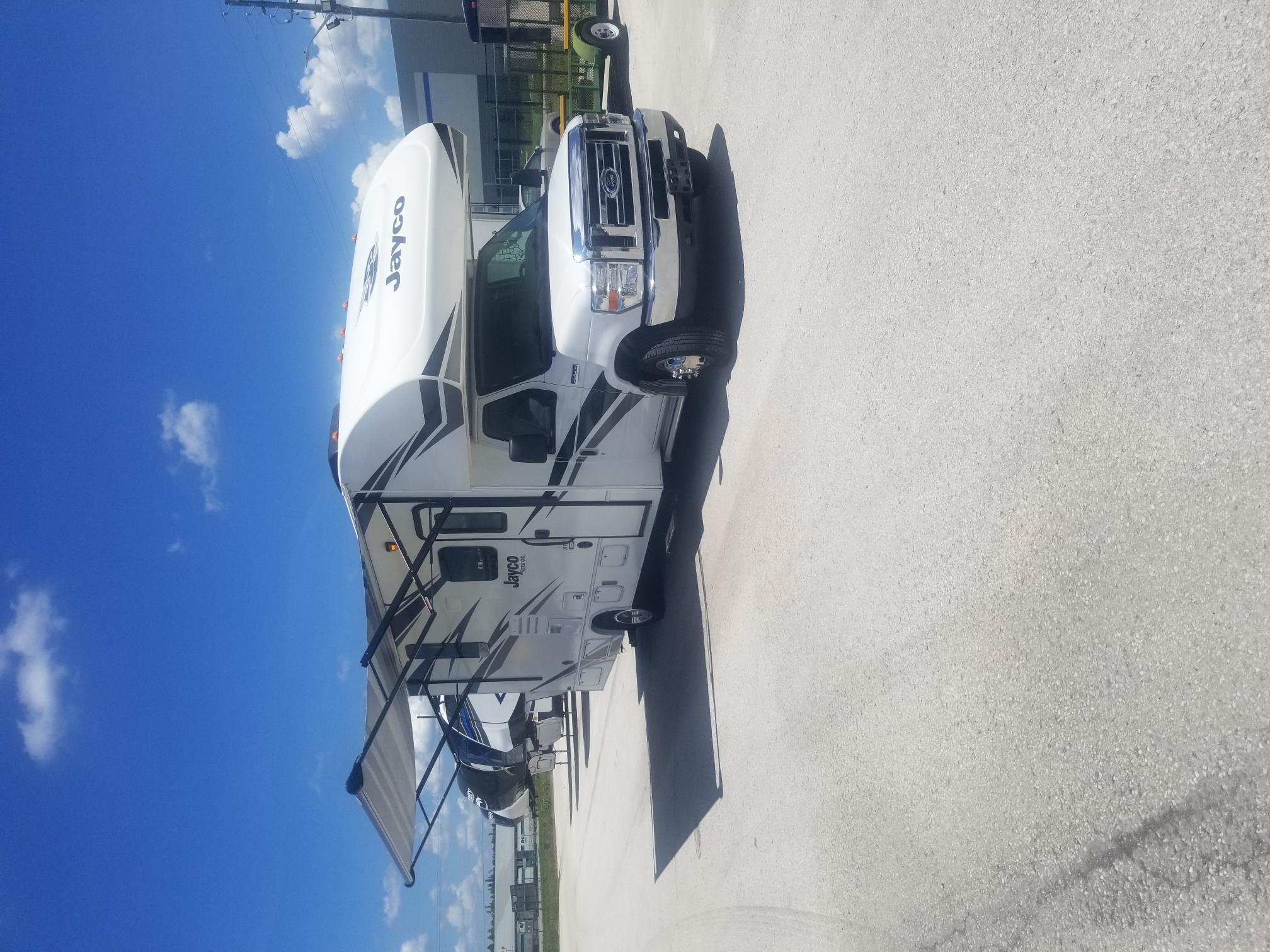 A white rv parked in a parking lot.