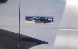 A close up of a white truck with a logo on it.