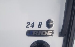 The door of a white rv with a number on it.