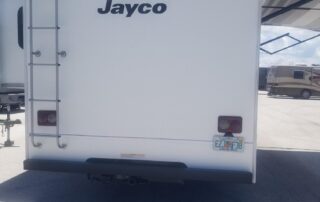 A white rv with the jayco logo parked in a parking lot.