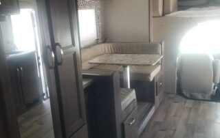 The interior of an rv with a bed and a kitchen.