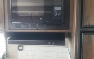 An rv kitchen with a microwave and oven.