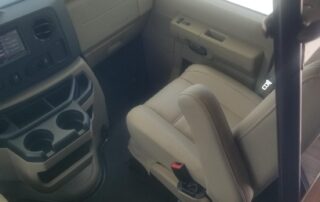 The interior of a van with leather seats and a steering wheel.