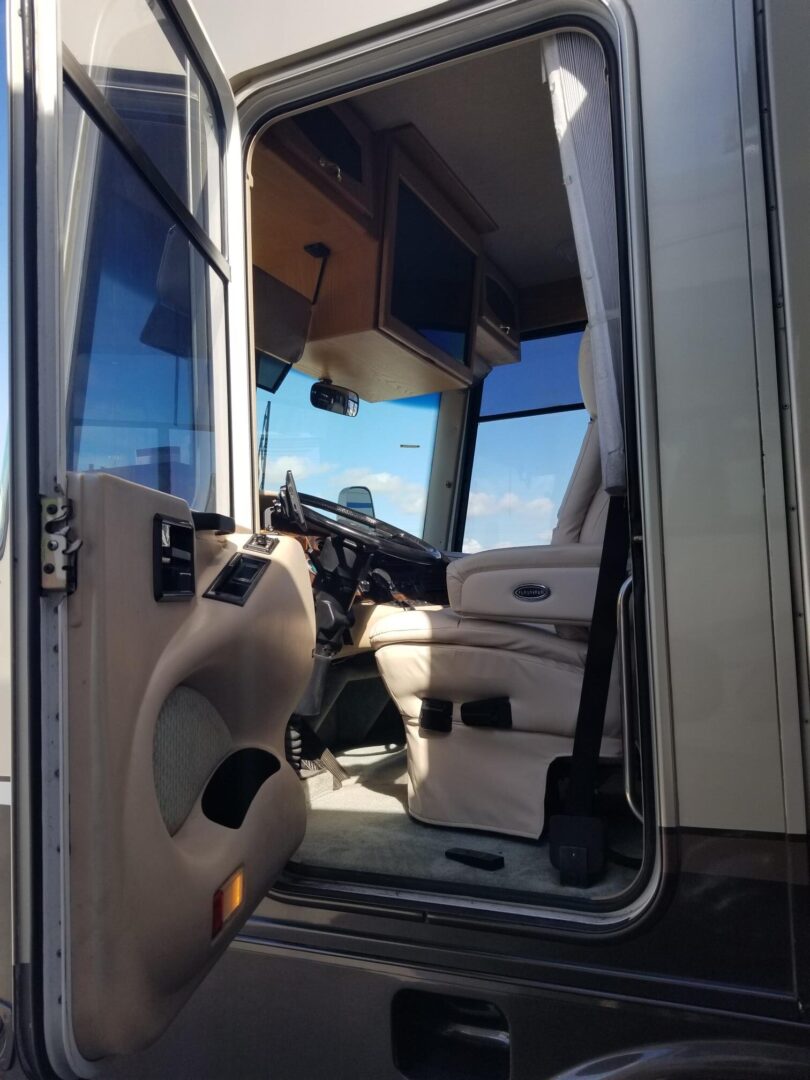 The door of a rv with a view of the driver's seat.