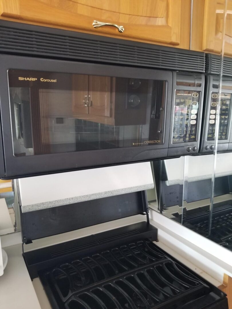 A microwave oven and oven in a kitchen.