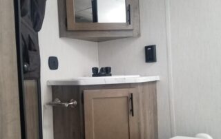 A bathroom in a small rv with a toilet and sink.