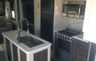 A kitchen in an rv with a stove and sink.