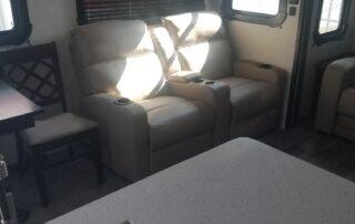 A small rv with a kitchen and living room.
