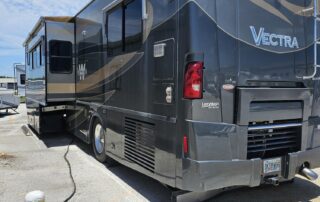 Gray and beige motorhome parked in lot.