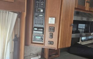 RV interior with control panel and seating.