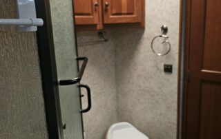 A bathroom with a toilet and shower stall.