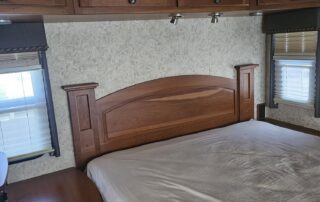 Bed with wooden headboard in a camper.