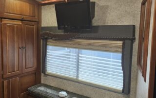 RV interior with a window seat and TV.