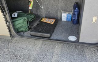 RV storage compartment with tools and supplies.