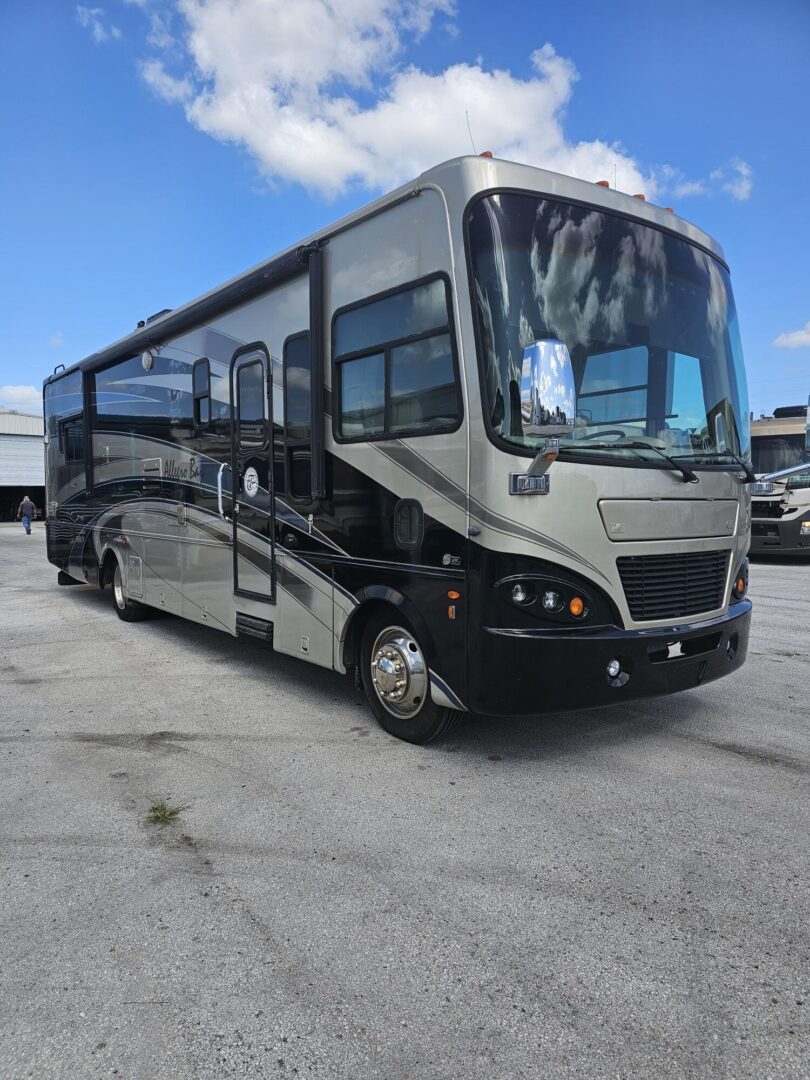 Silver and black RV parked on asphalt.