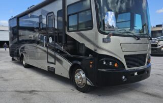 Silver and black RV parked outside.