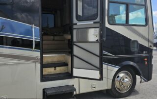 A white and black RV with an open door.