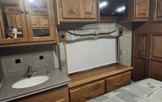 RV interior with sink and bed.