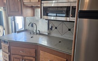 RV kitchen with stainless steel appliances.