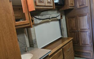 RV bathroom with wooden cabinets and sink.