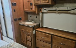 RV bedroom with wood cabinets and bed.